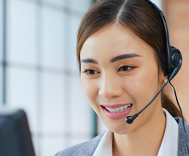 a smiling female customer care staff wearing a headset