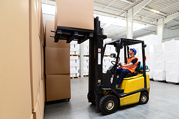 a warehouse worker driving a forklift